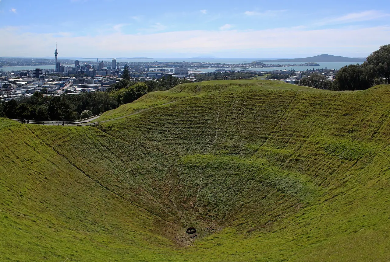 ปล่องภูเขาไฟ Mount Eden มองเห็นใจกลางเมืองและเกาะรางจิโตโตเป็นฉากหลัง ภาพจาก Wikimedia Commons ผู้ถ่าย Avenue สัญญา CC BY-SA 3.0
