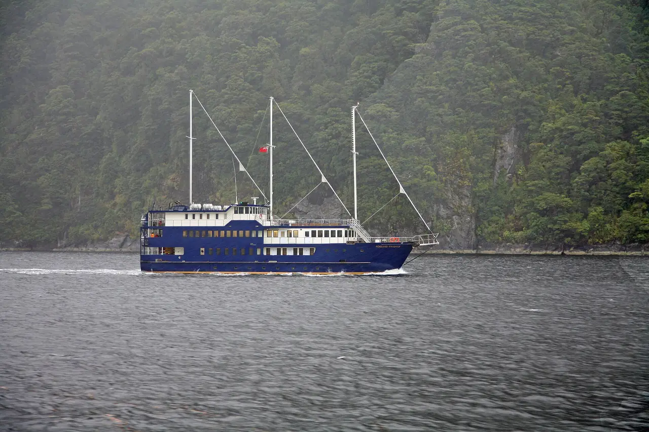 เรือล่องข้ามคืนในหมอกฝนบน Doubtful Sound ภาพจาก Wikimedia Commons ผู้ถ่าย W. Bulach สัญญา CC BY-SA 4.0 ไม่ระบุปี เป็นเรือที่เห็นระหว่างทัวร์ ไม่ใช่การยืนยันบริการของผู้ให้บริการรายใด