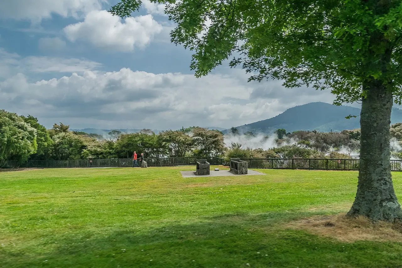 สวน Kuirau Park ในโรโตรัว มีไอน้ำจากแหล่งความร้อนใต้พิภพลอยอยู่หลังแนวต้นไม้ ภาพจาก Wikimedia Commons ผู้ถ่าย Krzysztof Golik สัญญา CC BY-SA 4.0