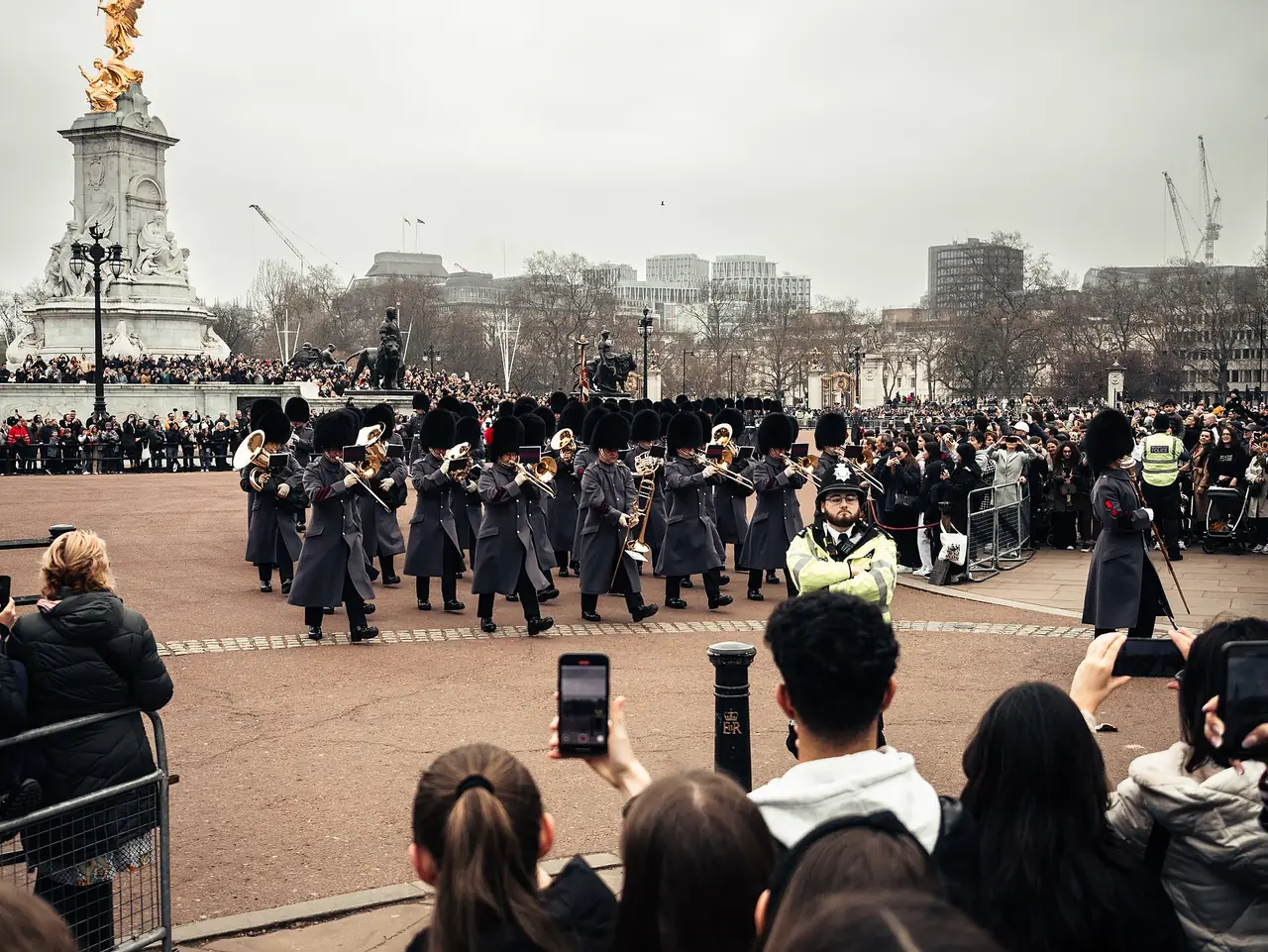 ทหารและวงดนตรีเดินในพิธีเปลี่ยนเวรหน้า Victoria Memorial มีผู้ชมยืนแน่นตามแนวกั้น ภาพจาก Wikimedia Commons ผู้ถ่าย Eliiezer สัญญา CC BY 4.0 ปี 2025