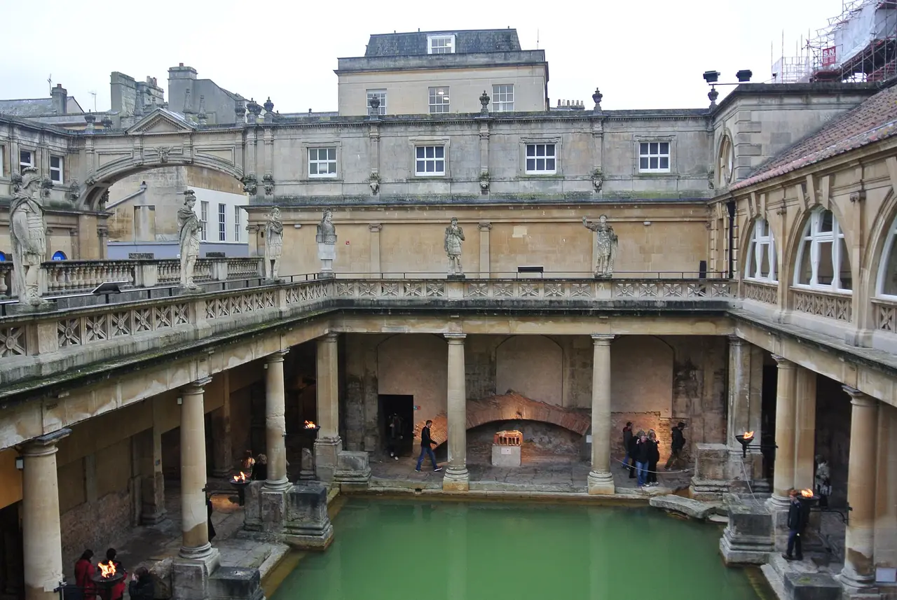 โรงอาบน้ำโรมันที่บาธ มองเห็นสระ Great Bath ด้านล่างและอาคารสมัยวิกตอเรียด้านบน ภาพจาก Wikimedia Commons ผู้ถ่าย Suicasmo สัญญา CC BY-SA 4.0 ถ่ายปี 2014