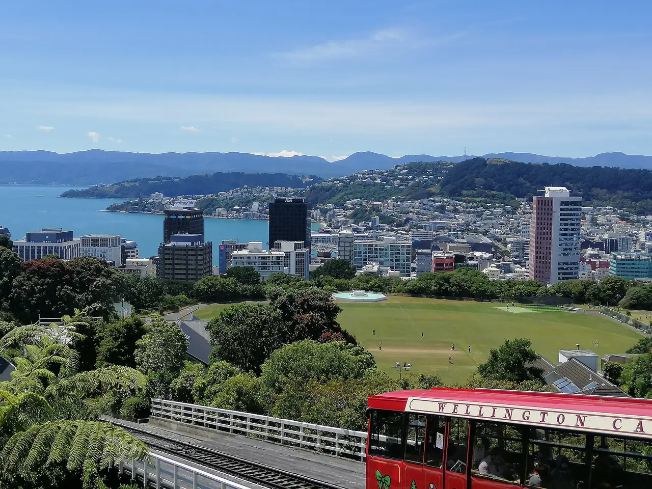 เมืองเวลลิงตันและรถรางกระเช้า Wellington Cable Car มองจากเนินเคลเบิร์น ภาพจาก Wikimedia Commons ผู้ถ่าย Panamitsu สัญญา CC BY-SA 4.0 ภาพประกอบเมืองหลวงของนิวซีแลนด์