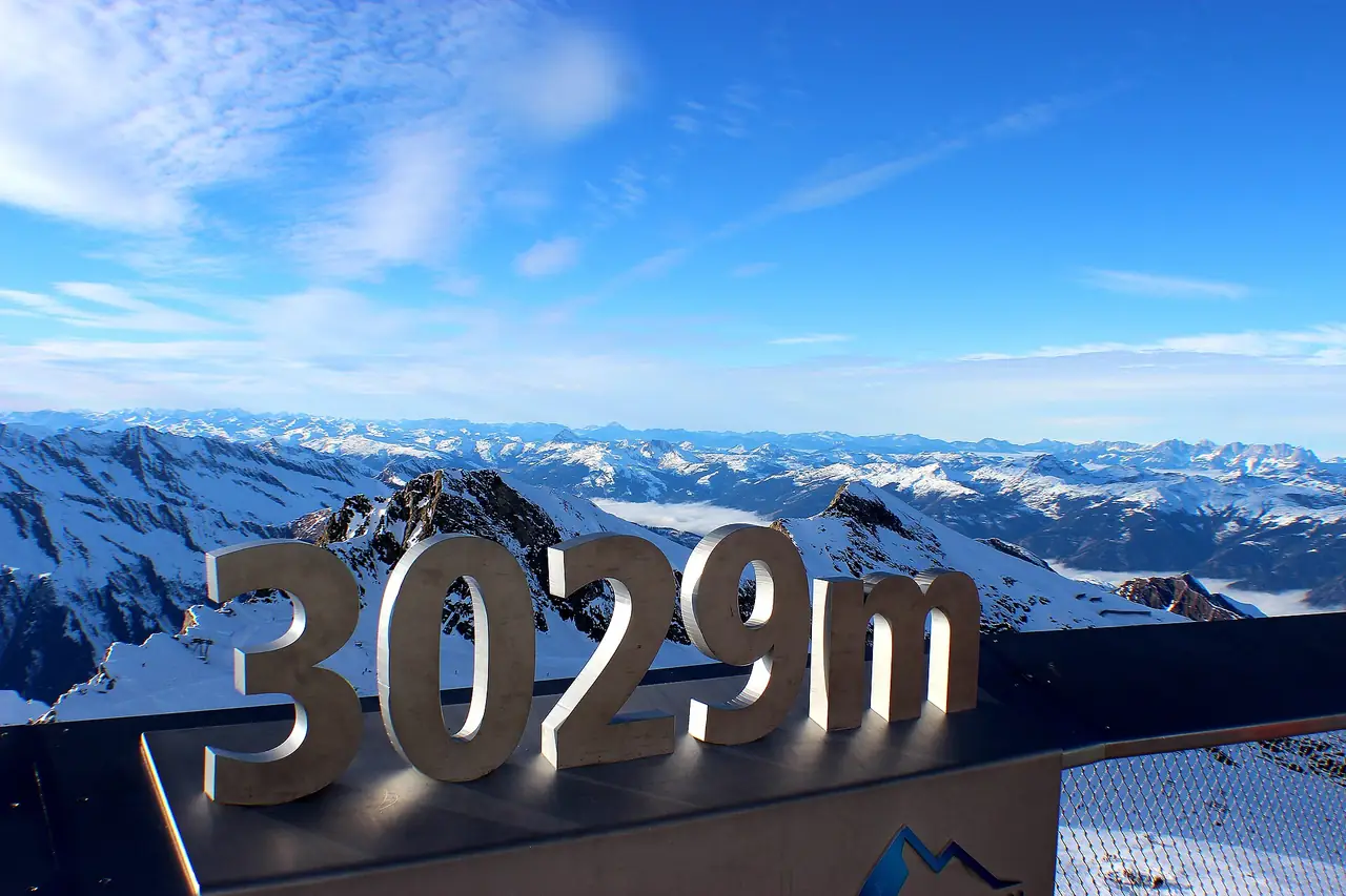 ป้ายตัวเลข 3029 m ที่จุดถ่ายภาพบนยอด Kitzsteinhorn ภาพจาก Wikimedia Commons ผู้ถ่าย Harald Kanins สัญญา CC BY-SA 2.0 ปีถ่ายไม่ระบุในที่เราตรวจ