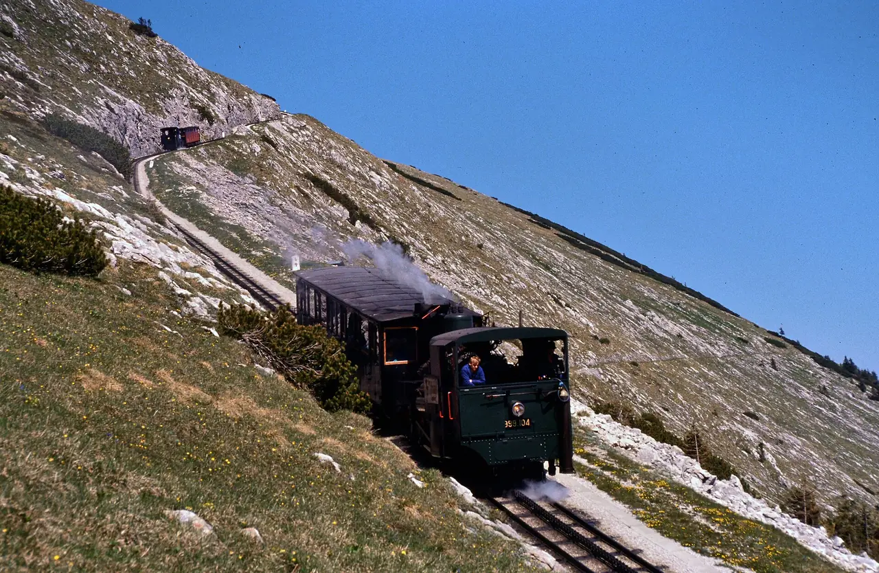 รถไฟไอน้ำฟันเฟืองของ Schafbergbahn บนทางลาดชัน ภาพจาก Wikimedia Commons ผู้ถ่าย Frank Nowotny สัญญา CC BY-SA 4.0 ปีถ่ายไม่ระบุในที่เราตรวจ เว็บผู้ให้บริการไม่ได้ยืนยันในที่เราอ่านว่าวันนี้วิ่งด้วยไอน้ำหรือดีเซล