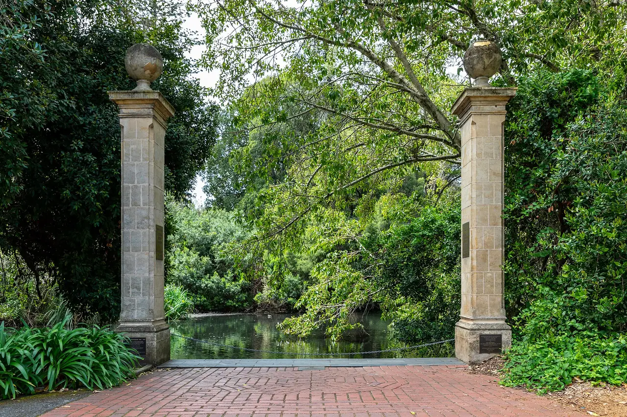 ประตูหินเข้าสวนที่ Adelaide Botanic Garden มีบ่อน้ำและต้นไม้เป็นฉากหลัง ภาพจาก Wikimedia Commons ผู้ถ่าย Dietmar Rabich สัญญา CC BY-SA 4.0 ถ่ายปี 2562