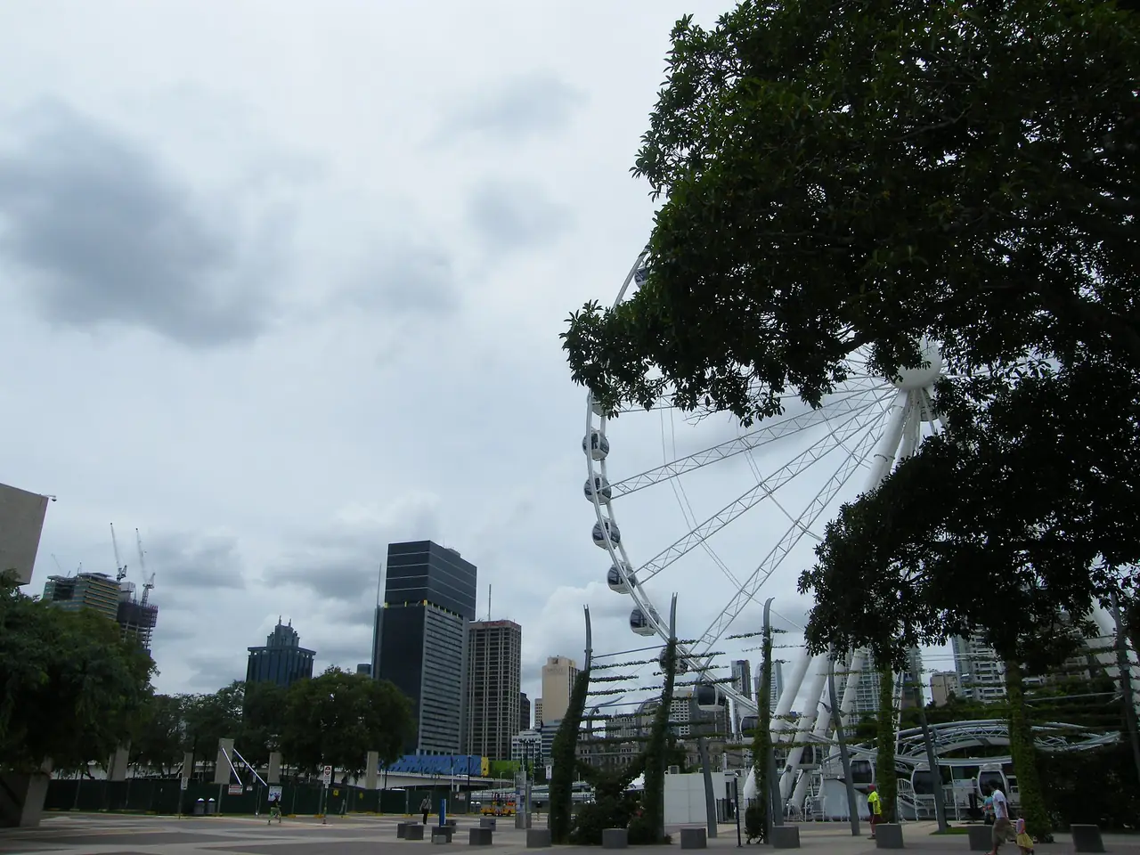 ชิงช้าสวรรค์ The Wheel of Brisbane มองจากสวน South Bank ในวันฟ้าครึ้ม ภาพจาก Wikimedia Commons ผู้ถ่าย John Robert McPherson สัญญา CC BY-SA 4.0