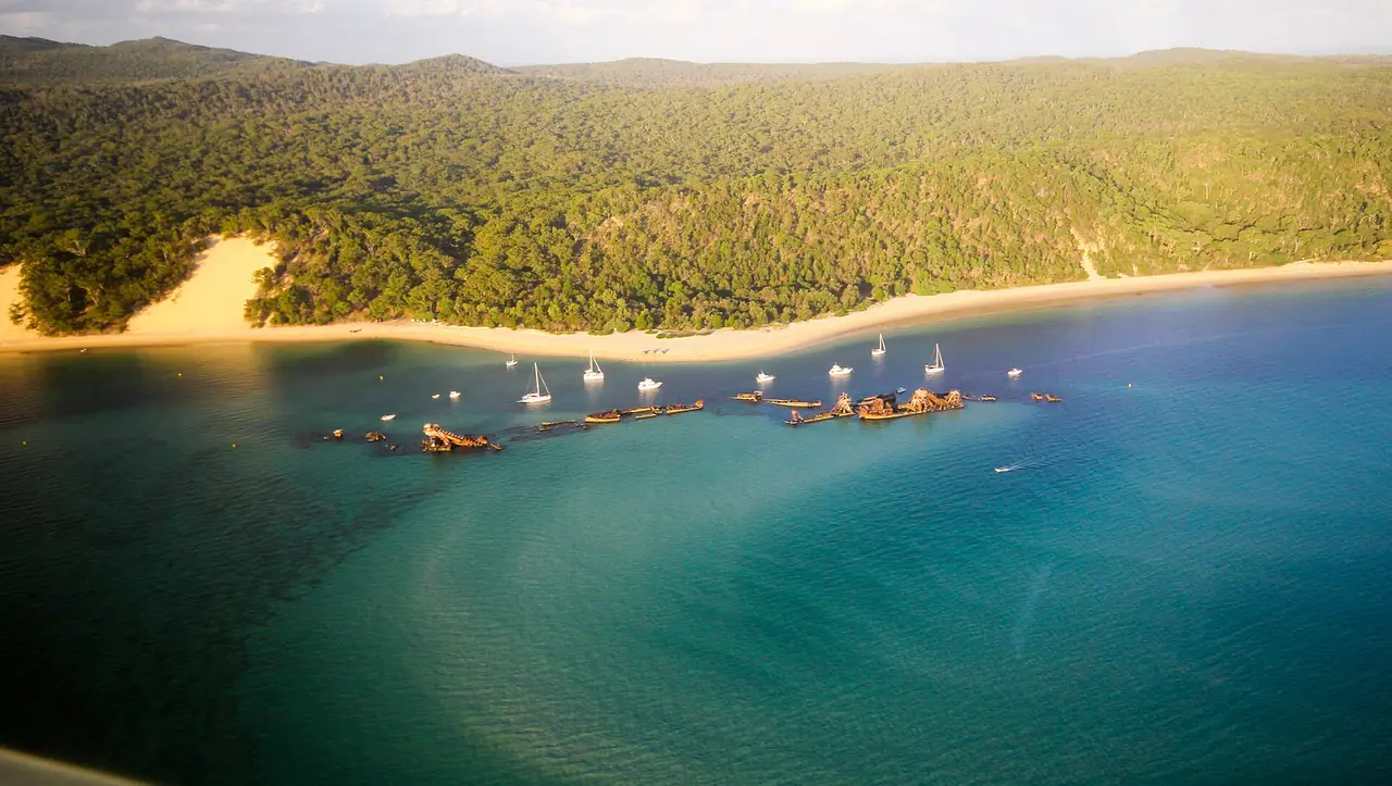 ซากเรือ Tangalooma Wrecks ที่จอดเป็นแนวกันคลื่นนอกชายหาดเกาะ Moreton ถ่ายจากมุมสูง ภาพจาก Wikimedia Commons ผู้ถ่าย Ishara Udawela สัญญา CC BY-SA 4.0