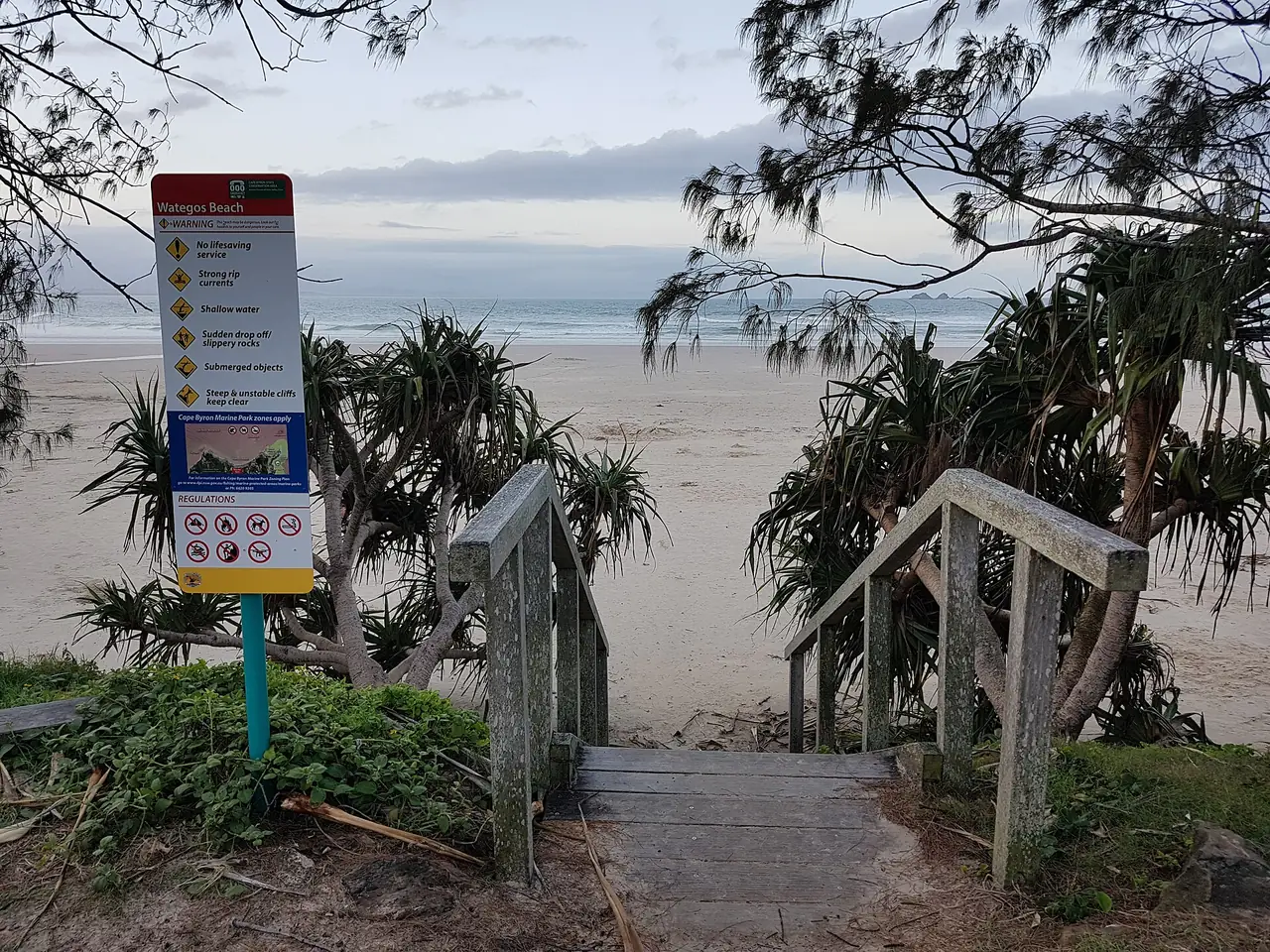 ทางเดินไม้ลงหาด Wategos Beach ที่ Byron Bay มีป้ายเตือนความปลอดภัยตั้งอยู่ข้างทาง ภาพจาก Wikimedia Commons ผู้ถ่าย Maksym Kozlenko สัญญา CC BY-SA 4.0 ถ่ายวันที่ 19 ธ.ค. 2563
