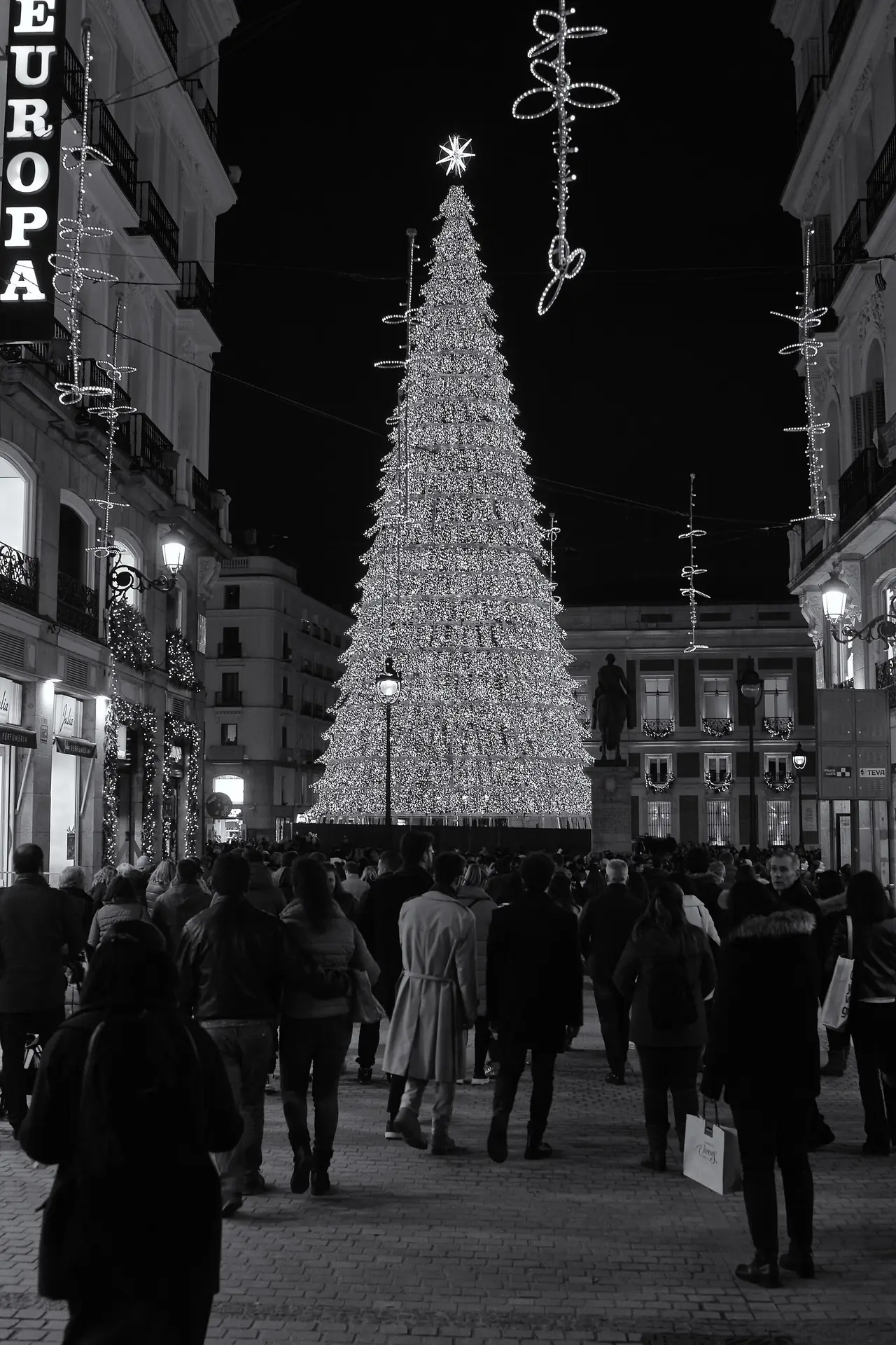 จัตุรัส Puerta del Sol ยามค่ำช่วงคริสต์มาส ภาพขาวดำ ภาพถ่ายจาก Wikimedia Commons ผู้ถ่าย Javier Perez Montes สัญญา CC BY-SA 4.0 ถ่ายเมื่อ ธ.ค. 2022 ไม่ใช่ภาพจากโรงแรม