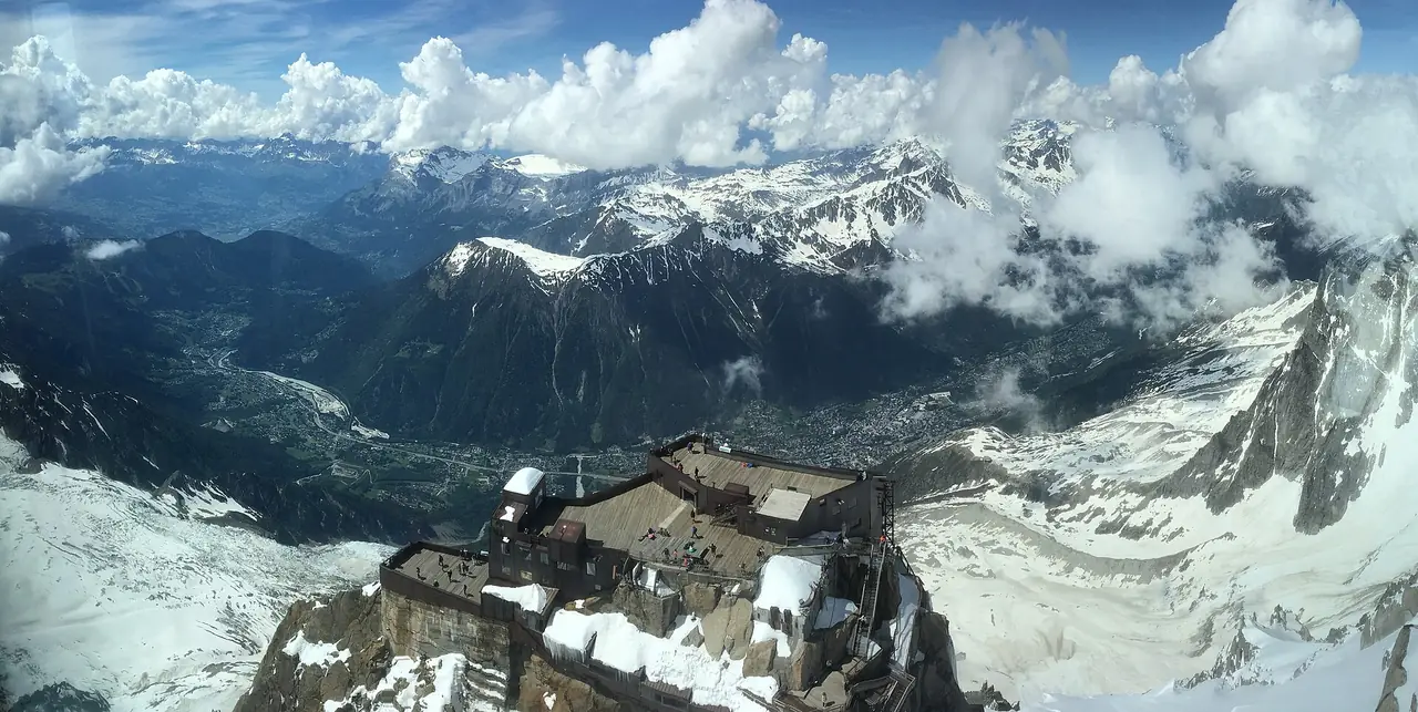 ชั้นลานด้านล่างของสถานีบน Aiguille du Midi มองจากยอดเห็นหุบเขา Chamonix ใต้ก้อนเมฆ ภาพปี 2018 จาก Wikimedia Commons ผู้ถ่าย Indresi สัญญา CC BY-SA 4.0
