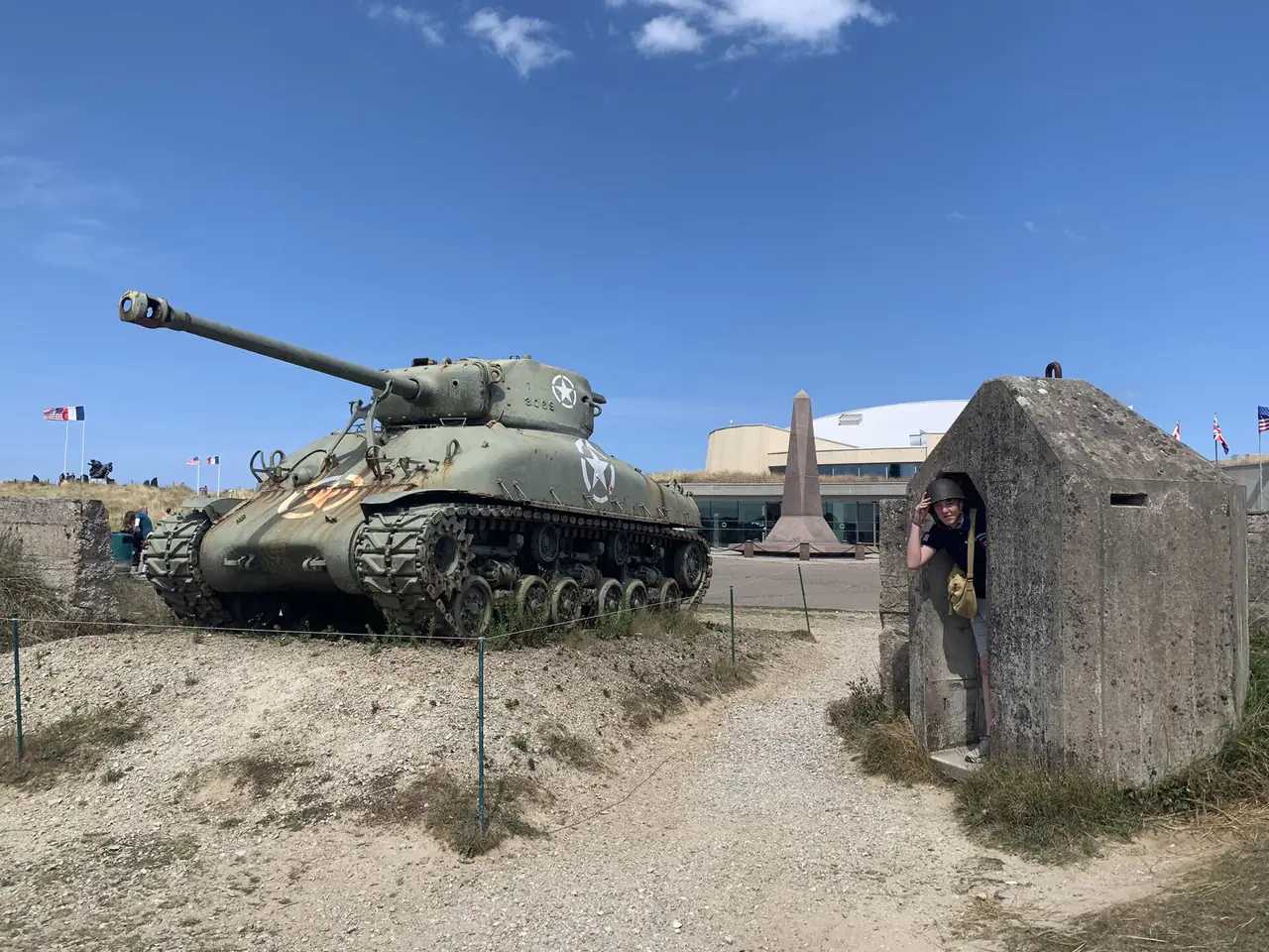 พิพิธภัณฑ์ Utah Beach มีรถถัง Sherman และบังเกอร์คอนกรีตหน้าอาคาร ภาพจาก Wikimedia Commons ผู้ถ่าย Jokke214 สัญญา CC BY-SA 4.0