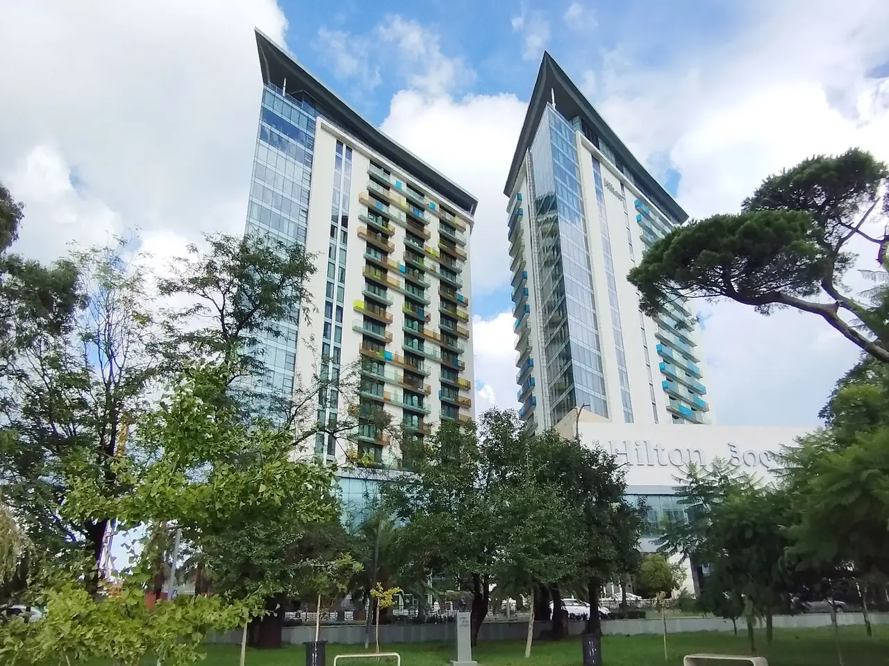 ตึกคู่ของ Hilton Batumi มองจากสวนใกล้เคียง เห็นตัวอักษรชื่อโรงแรมที่ฐานตึก ภาพจาก Wikimedia Commons ผู้ถ่าย Erez.Gt สัญญา CC BY-SA 4.0