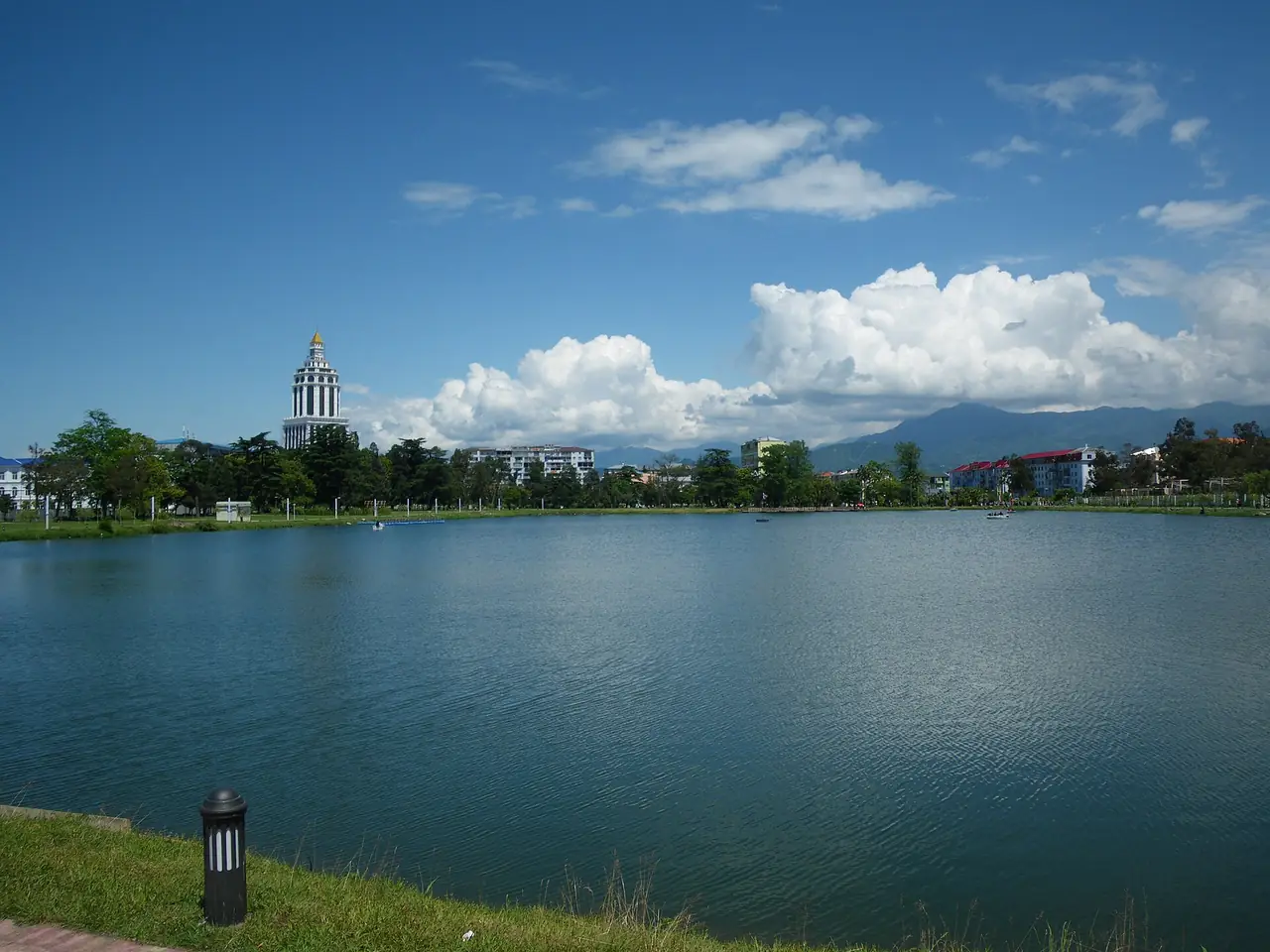 ทะเลสาบกลางเมืองบาทูมี เห็นหอคอยที่พักเป็นฉากหลังและเทือกเขาไกล ๆ ภาพจาก Wikimedia Commons ผู้ถ่าย mischvalente สัญญา CC BY 2.0 ชื่อไฟล์ระบุว่าเห็นโรงแรมฮิลตันกำลังก่อสร้างด้านหลัง จึงเป็นภาพเก่า