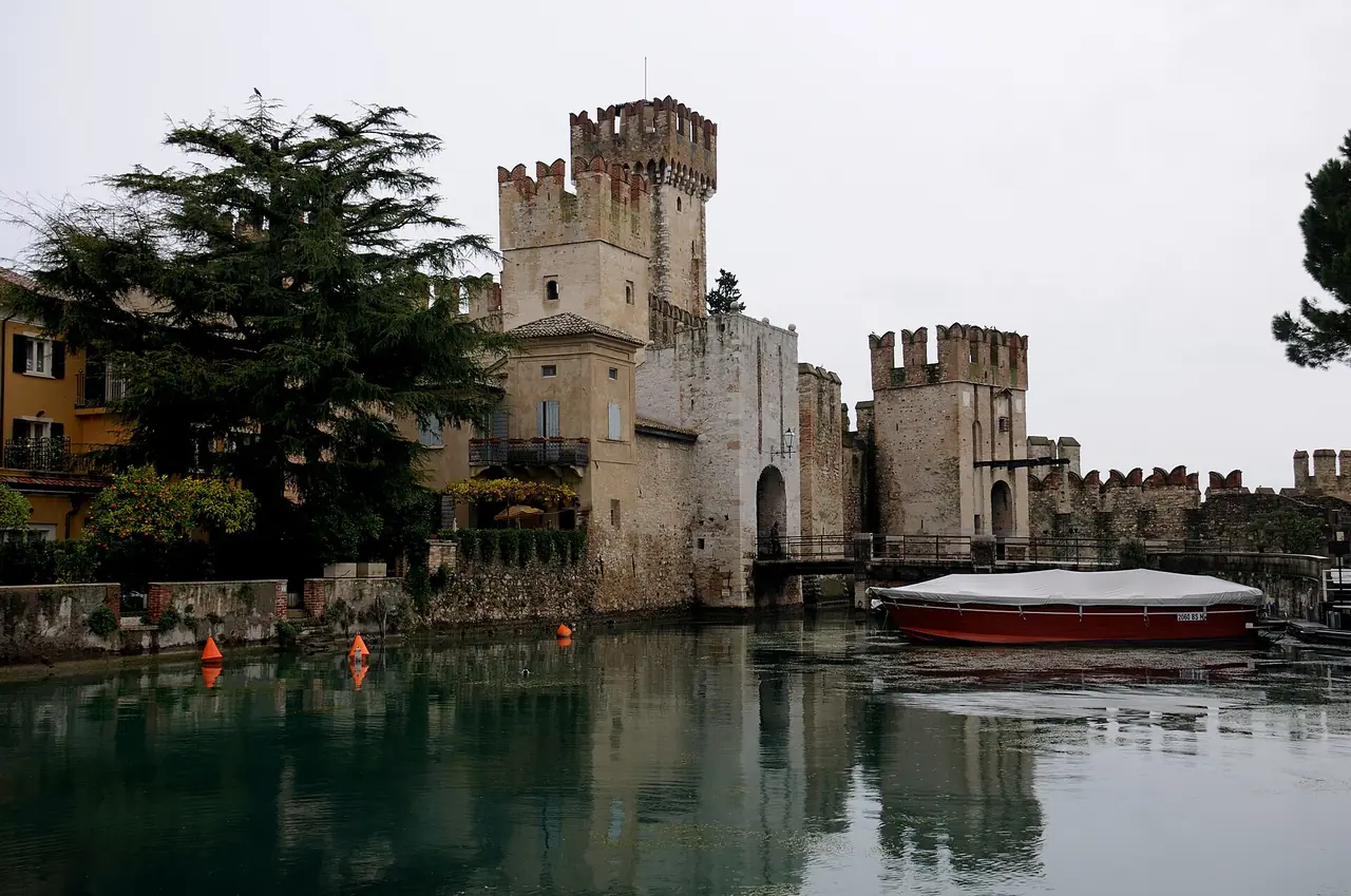 ปราสาท Scaligero และท่าเรือที่มีกำแพงล้อมที่ซีร์มิโอเน่ ภาพจาก Wikimedia Commons ผู้ถ่าย Josep M. Gracia สัญญา CC BY-SA 4.0 ถ่ายเมื่อปี 2557
