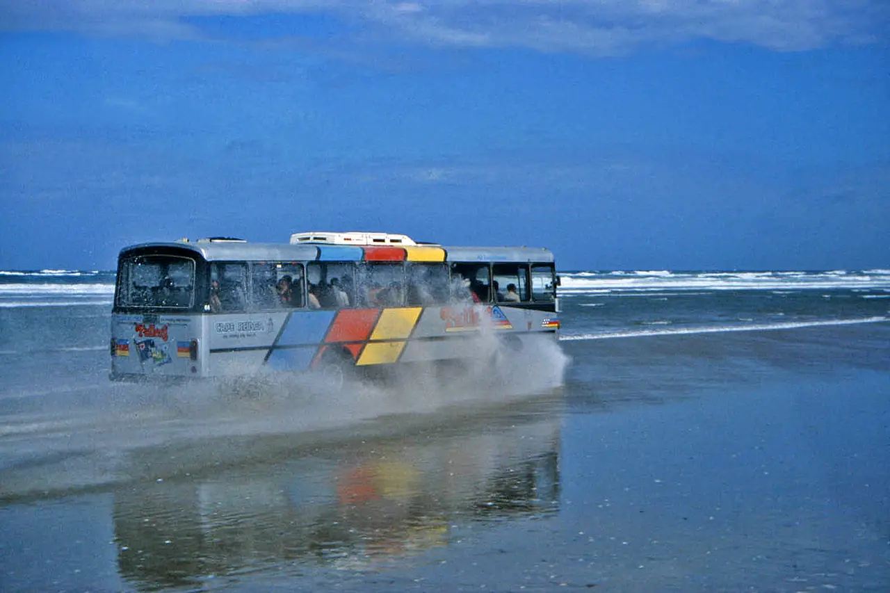 รถโค้ชวิ่งบนหาด Ninety Mile Beach ภาพจาก Wikimedia Commons ผู้ถ่าย W. Bulach สัญญา CC BY-SA 4.0 ไม่ระบุปี