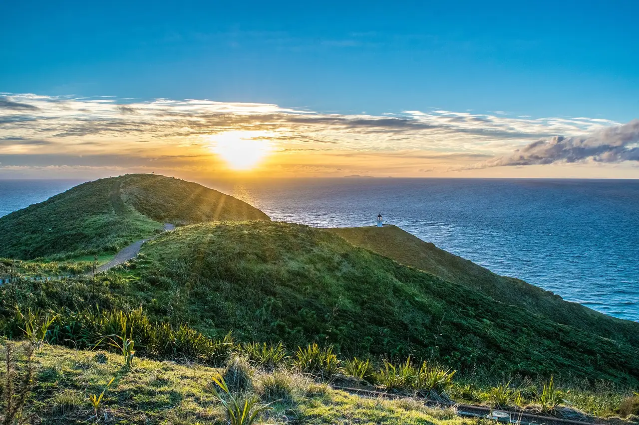 เนินหญ้าและประภาคารที่ Cape Reinga ตอนพระอาทิตย์ตก ภาพจาก Wikimedia Commons ผู้ถ่าย LuizCent สัญญา CC BY-SA 4.0 ไม่ระบุปี