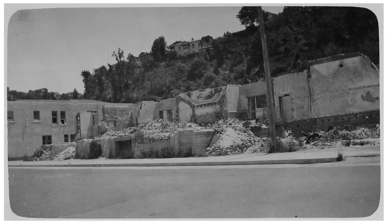 ภาพถ่ายหลังแผ่นดินไหวปี 2474 เห็นตึกพังและเนิน Bluff Hill ด้านหลัง ภาพจาก Wikimedia Commons ผู้เก็บ Archives New Zealand สัญญา CC BY-SA 2.0 ถ่ายปี 2474