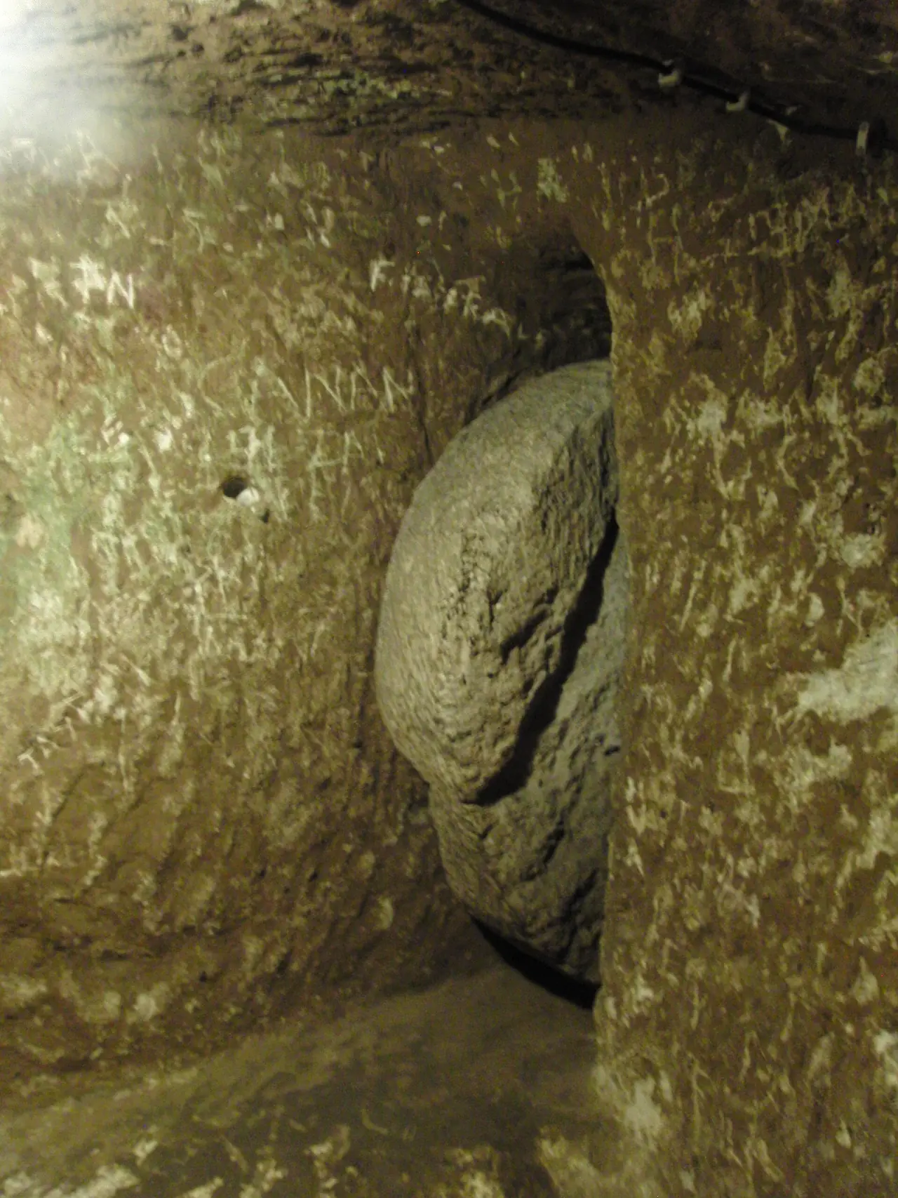 ประตูหินกลมที่ใช้กลิ้งปิดทางเดินแคบในเมืองใต้ดินเดริงคูยู ภาพจาก Wikimedia Commons ผู้ถ่าย TobyJ สัญญา CC BY-SA 4.0