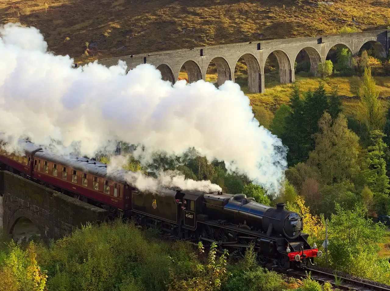 รถไฟไอน้ำ Jacobite กำลังผ่านสะพาน Glenfinnan ภาพจาก Wikimedia Commons ผู้ถ่าย Daniel Kraft สัญญา CC BY-SA 3.0 ถ่ายเดือนตุลาคม 2021