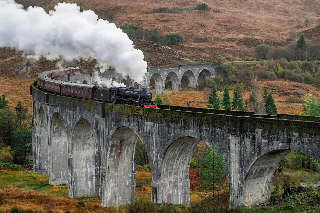 รถไฟ Jacobite บนสะพาน Glenfinnan ท่ามกลางผู้ชมจำนวนมากที่ยืนดูใกล้ ภาพจาก Wikimedia Commons ผู้ถ่าย Eric Kilby สัญญา CC BY-SA 4.0 ไม่ระบุปีในหน้า