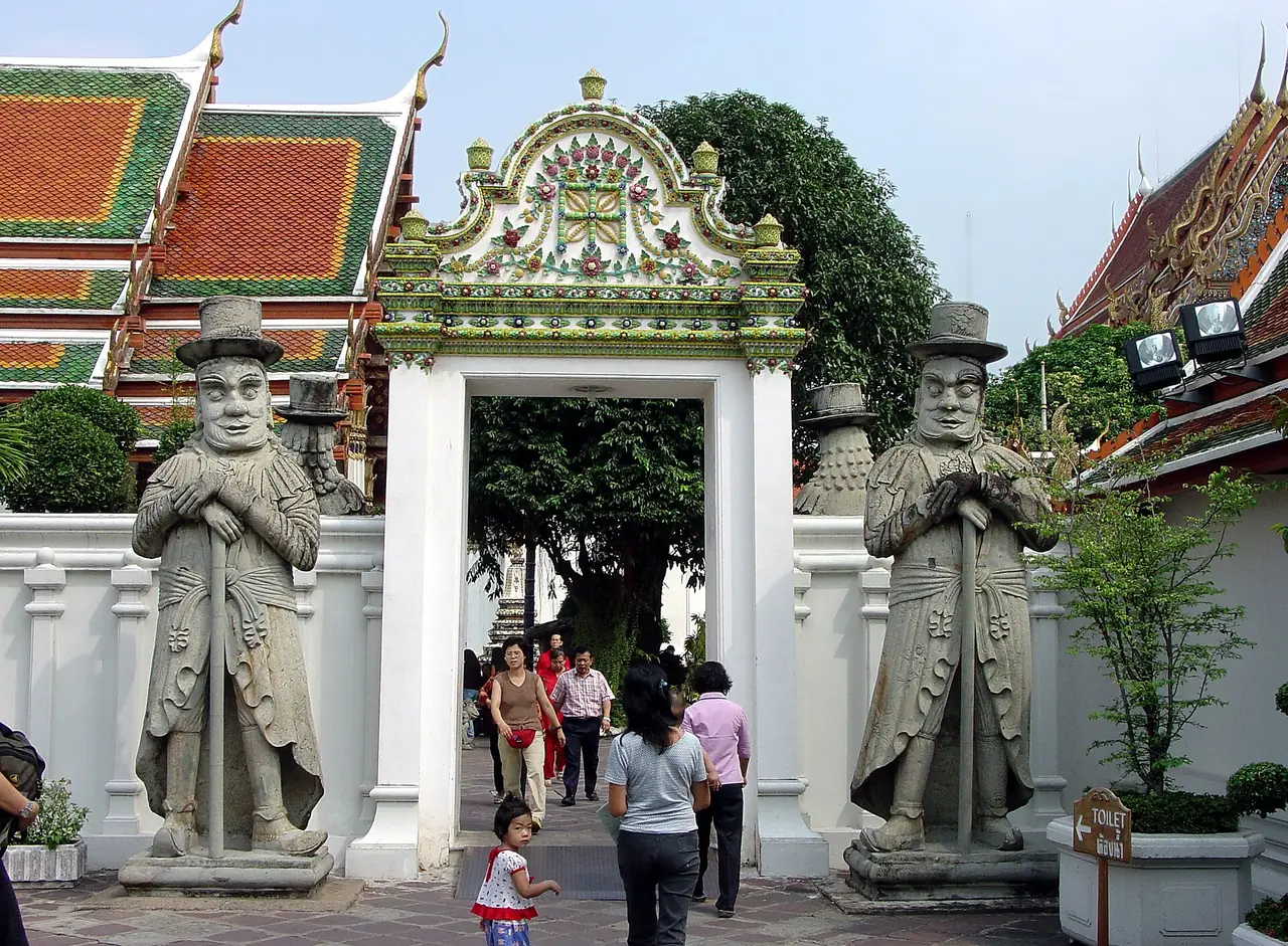 Stone guardian statues in Western dress at a Wat Pho gate